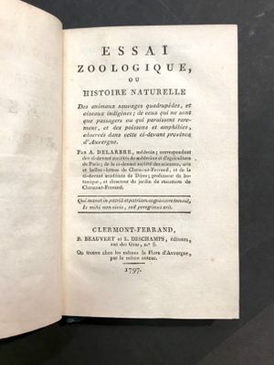 un livre ouvert posé sur une table, sur fond noir