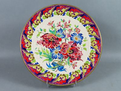 un gros plan d'une assiette décorée de fleurs, posée sur un support