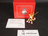 une petite boîte rouge sur laquelle est représenté un dragon en peluche