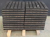 une pile de briques noires posée sur une palette en bois