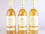 trois bouteilles de vin posées les unes à côté des autres sur une surface blanche