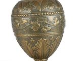 a gold vase that is sitting on a white surface