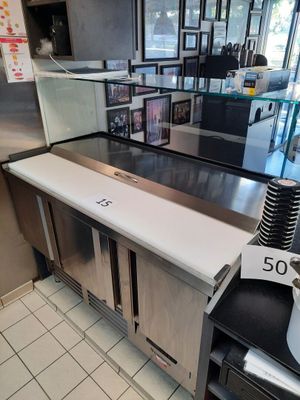 une cuisine équipée d'appareils électroménagers en inox et d'un plan de travail blanc