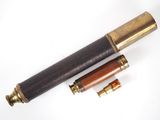 an old telescope with a wooden case and brass fittings on a white surface