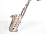 a silver saxophone sitting on a white surface