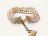 bracelet en perles orné d'une breloque en forme de cœur en or et d'une autre breloque en forme de cœur