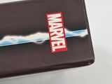 someone is holding a wallet with a marvel logo on it