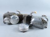 a silver motorcycle engine sitting on a white surface