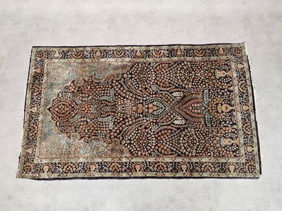 un vieux tapis à motifs floraux posé sur un sol blanc