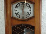 une horloge posée sur une étagère, elle-même posée sur une table