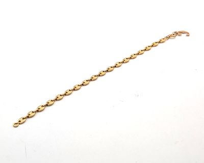 gros plan d'un bracelet en or sur une surface blanche