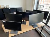 trois écrans d'ordinateur posés sur un bureau près d'une fenêtre