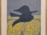 tableau représentant un oiseau noir survolant une fleur jaune, dans un cadre doré