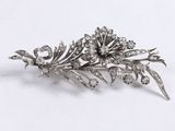 an image of a silver broochle with flowers and leaves