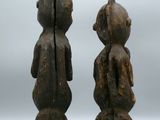 two wooden figurines of a boy and a girl standing next to each other