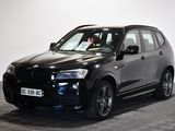 une photo d'un SUV BMW noir garé dans un showroom