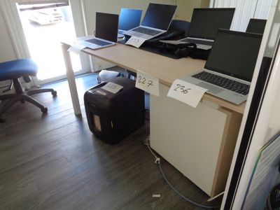 three laptops sitting on a desk in a room