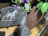 a stone plaque with a horse drawn carriage on it