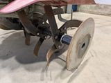 a close up of a tractor with a disc attached to it