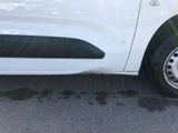 a small white car that is parked on the side of the road