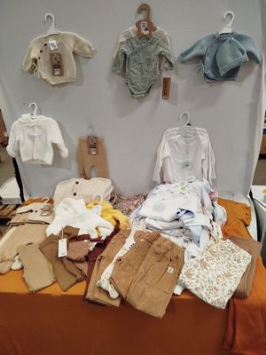 une table sur laquelle sont posés de nombreux vêtements pour bébés