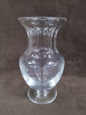 un vase en verre transparent posé sur une surface marron