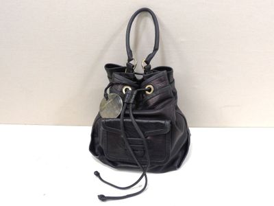 black leather handbag with a tag attached to it on a white surface