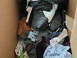 a cardboard box filled with clothes and clothing items