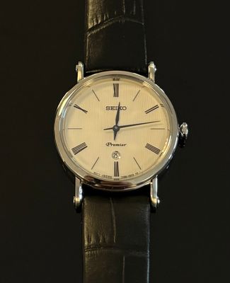 une image d'un gros plan d'une montre-bracelet sur une surface noire