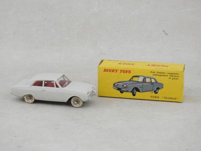 Une vieille petite voiture est posée à côté d'une boîte de jouets