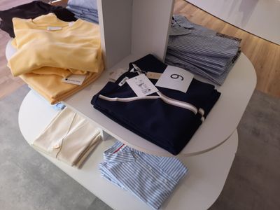une table blanche sur laquelle sont posés plusieurs vêtements