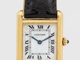 une image représentant une montre dorée et noire avec des chiffres romains