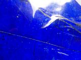 a close up of a blue glass with a bird on it
