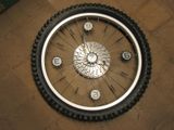 a clock on the floor with a bicycle tire on it