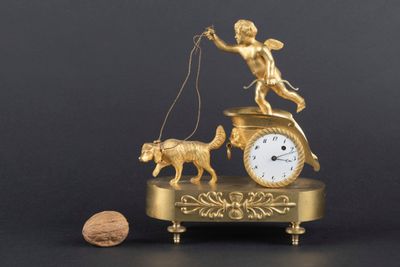 a gold figurine with a clock and a dog on a leash