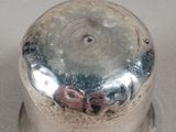 a silver container with a silver lid on a white surface