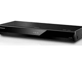 un lecteur DVD noir posé sur une surface blanche