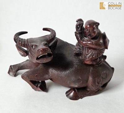 a figurine of a man riding a bull with a child on his back
