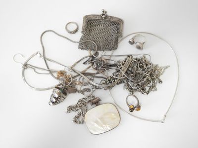 a pile of silver jewelry on a white surface