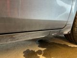 a close up of a car ' s bumper with a lot of dirt on the ground