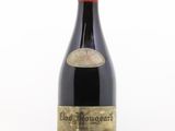 une vieille bouteille de vin rouge posée sur une table blanche