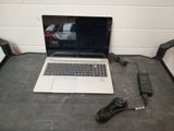a laptop that is sitting on a table with a charger