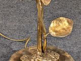 a gold plate with a flower on it on a table