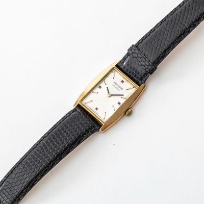 a watch that is sitting on a black leather strap