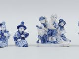 four blue and white figurines of people in various poses