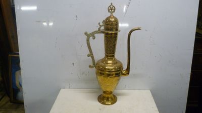 un trophée en or posé sur un socle blanc dans une pièce