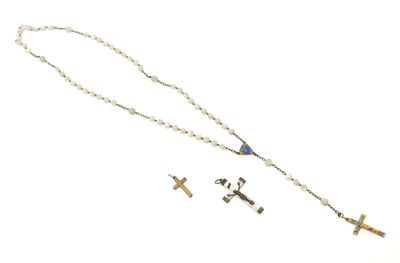 colliers avec chapelet et croix posés sur une surface blanche, sur fond blanc