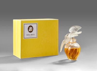 a bottle of perfume sitting next to a yellow box