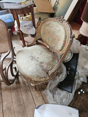 une chaise posée au milieu d'un tas de meubles