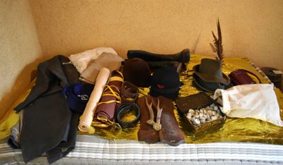 a bed that has a lot of hats and other items on it
